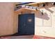 Charming winery entrance with rustic door, stucco walls and a decorative light fixture creating a unique inviting appeal at 3780 E Kellogg Rd, Pahrump, NV 89061