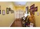 Bright hallway with an exit, hardwood floors, and framed wall art, complemented by a cozy seating area and a wooden sculpture at 3780 E Kellogg Rd, Pahrump, NV 89061