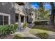 Condo building with green lawn, mature trees, and well-kept landscaping at 5250 S Rainbow Blvd # 2165, Las Vegas, NV 89118