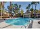 Beautiful community pool with palm trees, lounge seating, and a rock waterfall feature at 5250 S Rainbow Blvd # 2165, Las Vegas, NV 89118