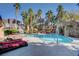 Relaxing community pool area featuring palm trees, a waterfall feature, and lounge chairs at 5250 S Rainbow Blvd # 2165, Las Vegas, NV 89118
