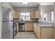 Open kitchen with stainless appliances, wood cabinets, and a breakfast bar at 5250 S Rainbow Blvd # 2165, Las Vegas, NV 89118
