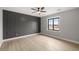 This bedroom features a gray accent wall, sleek ceiling fan, and wood-look flooring at 60 E Jaybird St, Pahrump, NV 89048