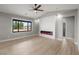 Bright living room featuring an electric fireplace, ceiling fan, and ample natural light at 60 E Jaybird St, Pahrump, NV 89048