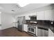 A kitchen with stainless steel appliances, white cabinets, and a breakfast bar at 6413 Chippindale Ln, Las Vegas, NV 89108