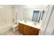 Bathroom featuring double sinks, wood vanity, and tub with shower at 6533 Adonis Heights Ave, North Las Vegas, NV 89086
