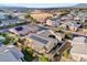 Neighborhood aerial view with solar panels, desert landscaping, grassy yards and a nearby school and recreation area at 7331 Abundant Harvest Ave, Las Vegas, NV 89131