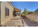 Backyard view of home with tan stucco, covered patio, desert landscaping and privacy wall at 7331 Abundant Harvest Ave, Las Vegas, NV 89131
