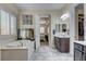 Bright bathroom with a soaking tub, double sinks and tile floors and open doorway to the main bedroom at 7331 Abundant Harvest Ave, Las Vegas, NV 89131