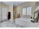Bathroom with a garden tub, tiled floors, walk-in shower, and an exterior door at 7331 Abundant Harvest Ave, Las Vegas, NV 89131