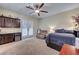 Spacious bedroom with a ceiling fan, lounge chair, and a convenient wet bar, perfect for relaxation at 7331 Abundant Harvest Ave, Las Vegas, NV 89131