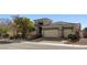 Contemporary home exterior with a brick driveway, multiple garages, and attractive landscaping at 7331 Abundant Harvest Ave, Las Vegas, NV 89131