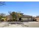 Beautiful exterior shot of home with a three car garage, stone accents, and manicured landscaping at 7331 Abundant Harvest Ave, Las Vegas, NV 89131