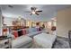Open floor plan with a large sectional, tile floors and a view into the kitchen at 7331 Abundant Harvest Ave, Las Vegas, NV 89131