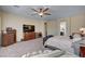 Large main bedroom featuring a flat screen TV, soft carpet, ceiling fan and plenty of storage space at 7331 Abundant Harvest Ave, Las Vegas, NV 89131