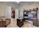 View of a functional office space with a large desk, comfortable chair and a door that leads to the kitchen area at 7331 Abundant Harvest Ave, Las Vegas, NV 89131