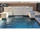 View of backyard pool with decorative stone waterfall feature, fire pit and pool water at 7331 Abundant Harvest Ave, Las Vegas, NV 89131