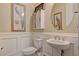 Powder room boasting custom framed wall art, a pedestal sink, and a toilet at 7331 Abundant Harvest Ave, Las Vegas, NV 89131