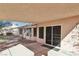 Covered backyard patio with desert landscaping and sliding glass door at 7501 Bush Garden Ave, Las Vegas, NV 89129