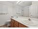 Bathroom featuring a double vanity with wood cabinets, a large mirror and a window at 7501 Bush Garden Ave, Las Vegas, NV 89129