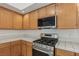 Kitchen detail: oak cabinets, stainless steel range, and tile countertops at 7501 Bush Garden Ave, Las Vegas, NV 89129