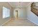 Bright living room features light wood floors, a chandelier, white trim, and a stairway with wood banisters at 7517 Cliff Peaks St, Las Vegas, NV 89149