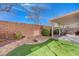 Landscaped backyard features artificial turf, a covered patio area, and privacy wall at 7815 Red Rock Ridge Ave, Las Vegas, NV 89179