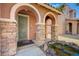 Covered porch with stone pillars and a decorative pond leading to the front door at 7815 Red Rock Ridge Ave, Las Vegas, NV 89179