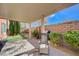 Paver patio features a covered area and is landscaped with mature trees, brick walls and turf at 7815 Red Rock Ridge Ave, Las Vegas, NV 89179