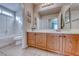 Bathroom with tiled floor, wood vanity, a shower-tub combo, and decor at 8519 Little Fox St, Las Vegas, NV 89123