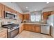 Well-equipped kitchen with stainless steel appliances, light wood cabinets, and tiled backsplash at 8519 Little Fox St, Las Vegas, NV 89123