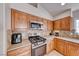 Close-up of kitchen with stainless steel appliances and oak cabinets, complimented by attractive backsplash at 8519 Little Fox St, Las Vegas, NV 89123