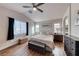 Main bedroom showcasing wood floors, a ceiling fan, and lots of natural light from large windows at 8519 Little Fox St, Las Vegas, NV 89123