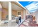 Covered patio area with wrought iron table and chairs, gas grill, privacy fence and sliding glass door at 8519 Little Fox St, Las Vegas, NV 89123
