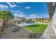The backyard offers grass, desert landscaping, a pergola, and a pool at 9475 W Rosada Way, Las Vegas, NV 89149