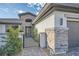 Close-up of the home's entrance featuring a modern gate, stone accents, and contemporary lighting at 9475 W Rosada Way, Las Vegas, NV 89149