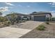 Beautiful single-story home featuring a three-car garage, desert landscaping, and a charming stone facade at 9475 W Rosada Way, Las Vegas, NV 89149