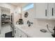 Bright kitchen with white cabinets, quartz countertops, black hardware, and stainless steel refrigerator at 9475 W Rosada Way, Las Vegas, NV 89149