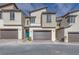 Modern townhouse with attached garages and a blue front door at 11940 Vector Ray Ave, Las Vegas, NV 89138