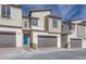 Modern townhouses with attached garages and eye-catching blue door at 11940 Vector Ray Ave, Las Vegas, NV 89138