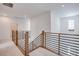 Hallway with modern wooden railings and neutral carpet, offering an open and bright transition between spaces at 11940 Vector Ray Ave, Las Vegas, NV 89138