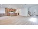 Open-concept living area featuring light wood-look floors, a modern staircase, and a seamless flow into the kitchen at 11940 Vector Ray Ave, Las Vegas, NV 89138