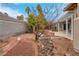 Beautiful backyard landscaping featuring river rock, mature plants and a covered patio at 1433 Erskine Ave, Las Vegas, NV 89123