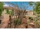 Charming backyard with mature trees and a covered patio with natural landscaping at 1433 Erskine Ave, Las Vegas, NV 89123