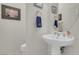 Half bathroom features a white pedestal sink with fixtures and a nearby toilet at 1433 Erskine Ave, Las Vegas, NV 89123