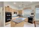 Well-lit kitchen featuring a center island, ample cabinet space, and modern oven at 1433 Erskine Ave, Las Vegas, NV 89123