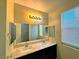 Bright bathroom with double sinks, marble countertop, and a large mirror at 1630 Meadow Bluffs Ave, Henderson, NV 89014