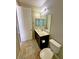 Small bathroom with a toilet, dark wood vanity with a sink, and a white door at 1630 Meadow Bluffs Ave, Henderson, NV 89014