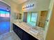 Primary bathroom with dual sinks, a large mirror, and updated finishes at 1630 Meadow Bluffs Ave, Henderson, NV 89014
