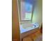 Cozy bathroom with a tiled corner bathtub and natural light at 1630 Meadow Bluffs Ave, Henderson, NV 89014